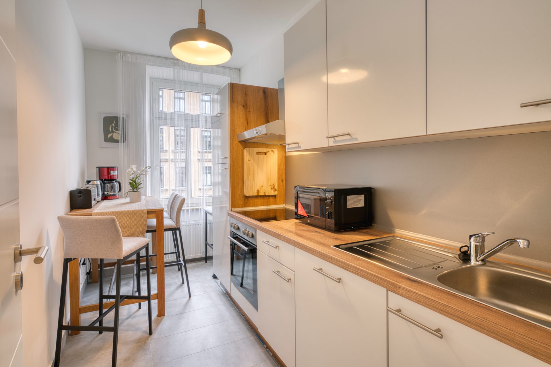Minimalistischer Esstisch aus Holz mit stilvoller Beleuchtung. Fotograf für Ferienwohnung