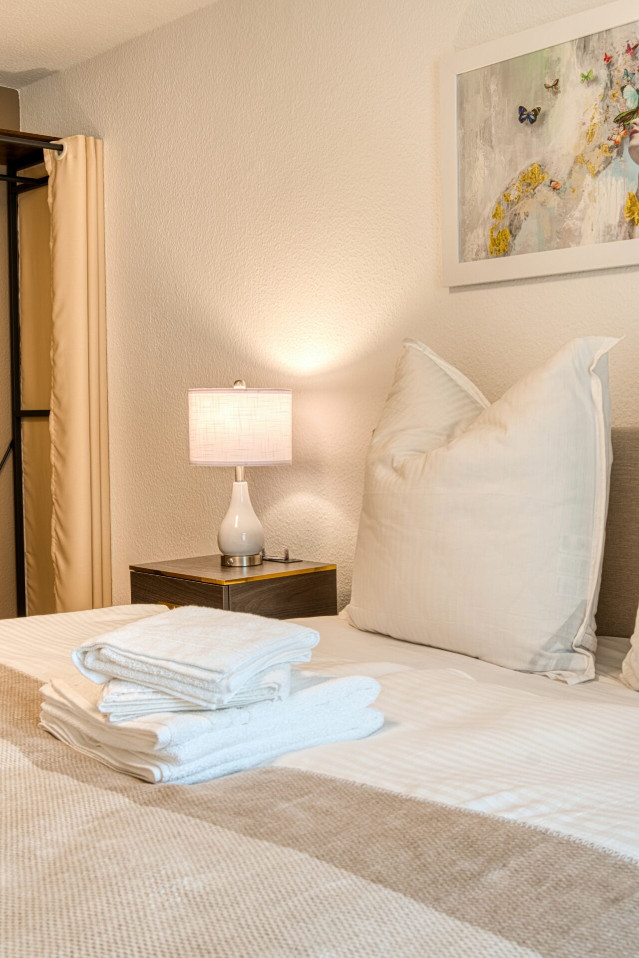 Boxspringbett mit Kissen und Handtüchern einer Ferienwohnung in Leipzig. Immobilienfotografie in Leipzig, Dresden, Halle.