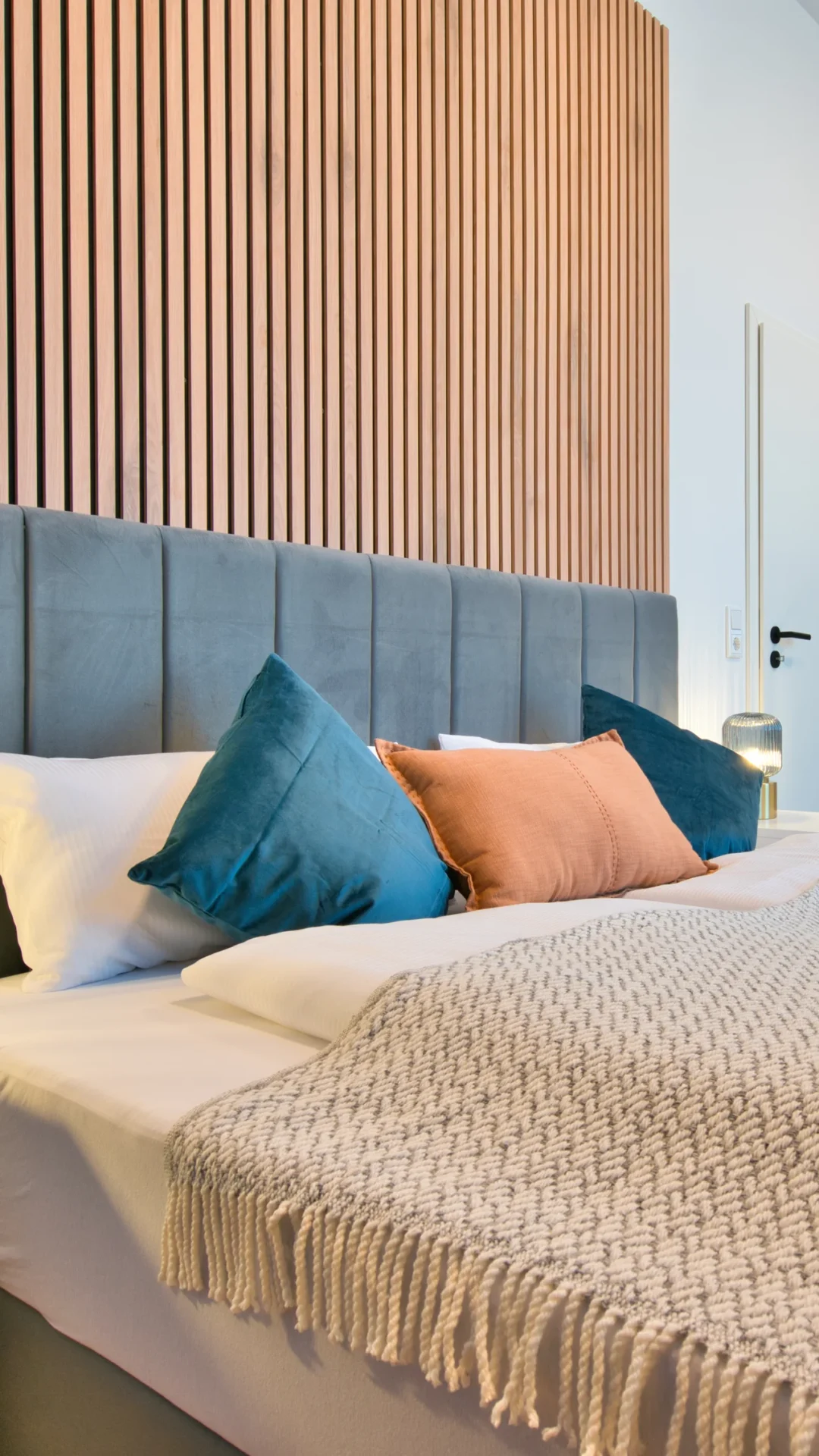 Bett mit modernen Wandpaneelen und stilvoller Dekoration